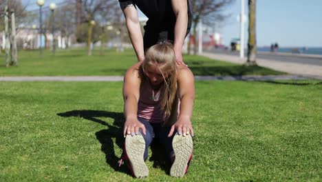 Young-woman-stretching-before-training-in-park.